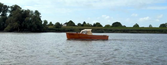 Klassische Motoryacht wandert entlang der Elbe bei Wedel in Fahrt auf Hamburg Blankenese