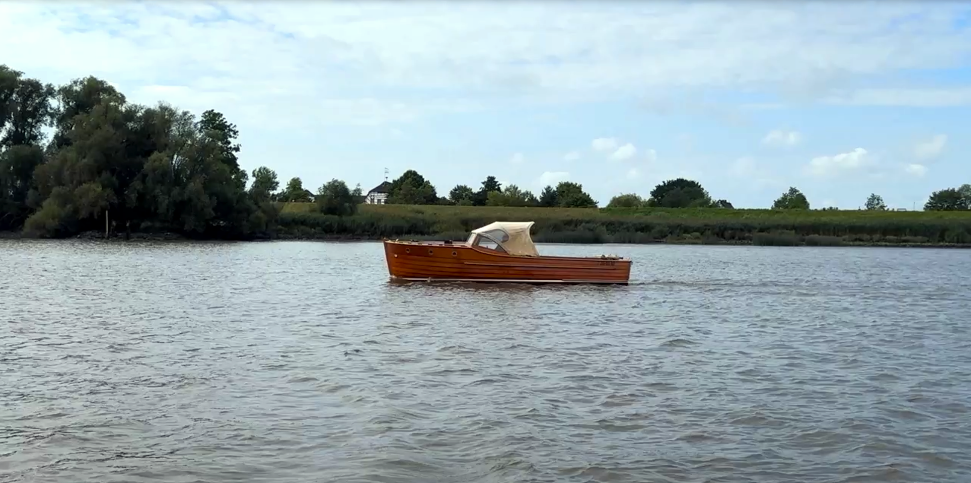 Klassische Motoryacht wandert entlang der Elbe bei Wedel in Fahrt auf Hamburg Blankenese